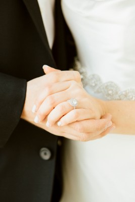 close up of engagement ring holding hands