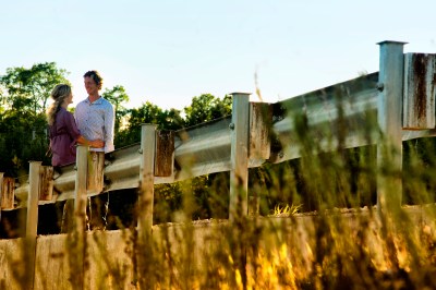 engaged couple tender looks on bridge